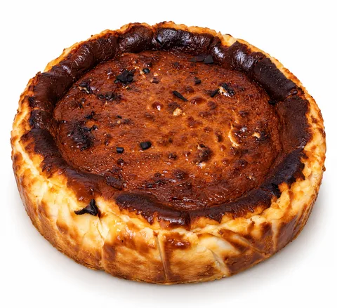 Bütün San Sebastian cheesecake; üstü koyu karamelize, kenarları yanık görünümlü.